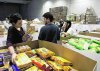 Varios voluntarios catalogan las cajas de alimentos en una de las naves de Mercasalamanca. / ALMEIDA